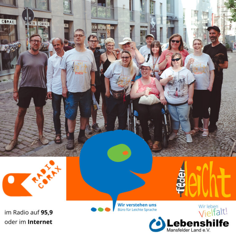 Eine bunte Gruppe von Menschen, darunter eine Person im Rollstuhl, posiert und lächelt gemeinsam auf einer Kopfsteinpflasterstraße. Am unteren Rand erscheinen Logos und Texte von Radio Corax, federleicht und der Lebenshilfe.